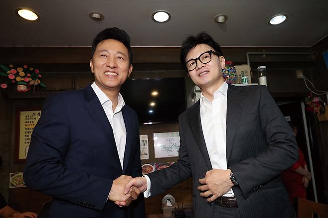 오세훈 서울시장(왼쪽)과 한동훈 국민의힘 당대표 후보가 전당대회 중이던 7월5일 서울 용산구 쪽방촌 동행식당에서 만나 악수하고 있다. ⓒ연합뉴스
