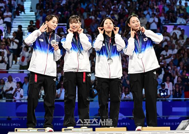 한국 펜싱 여자 사브르 대표팀(왼쪽부터 윤지수, 전하영, 전은혜, 최세빈)이 4일(한국 시간) 프랑스 파리 그랑팔레에서 열린 2024 파리올림픽 펜싱 여자 사브르 단체전에서 은메달을 딴 뒤 시상대 위에서 귀걸이를 뽐내는 세리머니를 하고 있다. 선수들은 태극기의 4괘와 태극 문양이 새겨진 귀걸이를 함께 착용하고 경기에 나섰다. 2024. 8. 4.  파리 | 박진업 기자 upandup@sportsseoul.co.