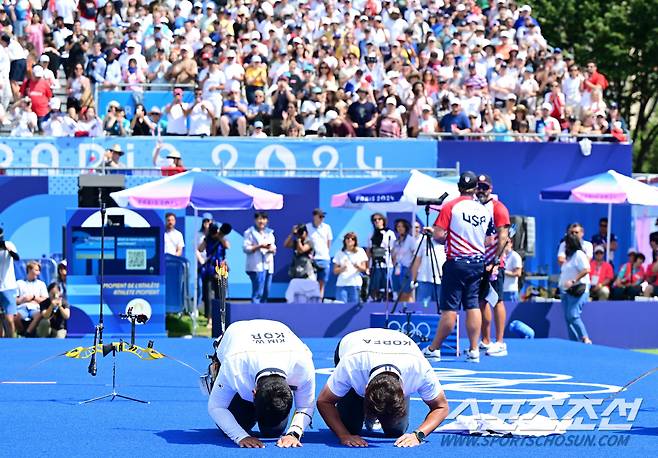 4일(한국시간) 프랑스 파리 레쟁발리드에서 '2024 파리올림픽' 양궁 남자 리커브 개인 금메달결정전 한국 김우진과 미국 브래들리 엘리슨의 경기가 열렸다. 김우진이 마지막 슛오프 끝에 금메달을 거머쥐었다. 금메달 김우진이 박성수 감독과 관중석을 향해 절을 하고 있다. 파리(프랑스)=정재근 기자 cjg@sportschosun.com/2024.08.04/