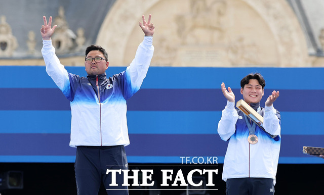 한국 양궁 대표팀 김우진(왼쪽)과 이우석이 4일(현지 시간) 프랑스 파리 앵발리드에서 열린 2024 파리 올림픽 양궁 남자 개인전 시상식 시상대에 올라 두 팔을 들어 올리고 있다. /뉴시스