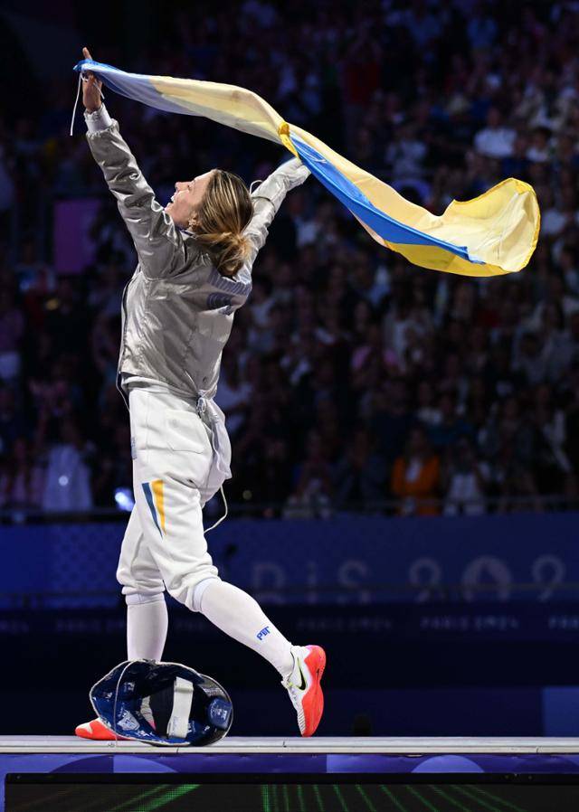 3일(현지시간) 프랑스 파리 그랑팔레에서 열린 2024 파리 올림픽 펜싱 여자 사브르 단체전 결승 한국과 우크라이나의 경기에서 금메달을 딴 우크라이나 대표팀의 올하 하를란이 국기를 들고 세리머니를 하고 있다. 파리=서재훈 기자