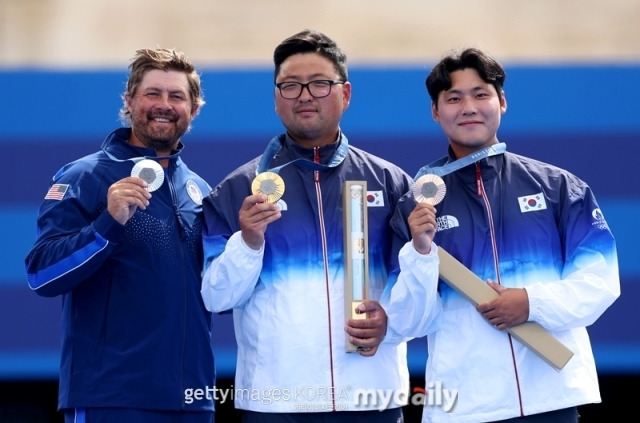 파리올림픽 남자 양궁 개인전 정상에 오른 김우진(가운데)과 동메달을 딴 이우석(오른쪽)이 시상식에서 메달을 들고 포즈를 취하고 있다./게티이미지코리아