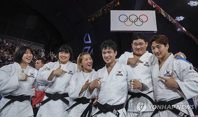 우리는 한국 대표선수다! (파리=연합뉴스) 신준희 기자 = 3일(현지시간) 프랑스 파리 샹드마르스 경기장에서 열린 대회 유도 혼성단체전 동메달 결정전에서 마지막 대전에 나선 한국의 안바울이 혈전끝에 승리한 뒤 선수들이 태극기를 가리키며 승리의 세리머니를 하고 있다.
    한국 혼성유도팀은 독일을 4-3으로 꺾어 동메달을 획득했다. 2024.8.4 hama@yna.co.kr