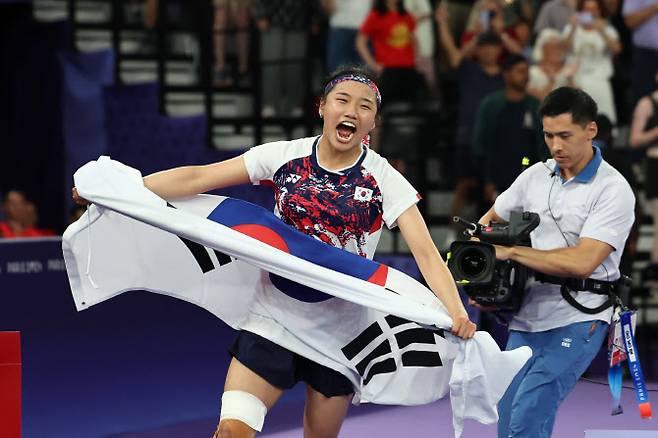 5일(현지시간) 프랑스 파리 포르트드 라 샤펠 아레나에서 열린 2024 파리올림픽 배드민턴 여자 단식 결승전에서 한국 안세영이 중국 허빙자오를 이기고 우승을 확정한 뒤 태극기를 들고 환호하고 있다.사진=연합뉴스