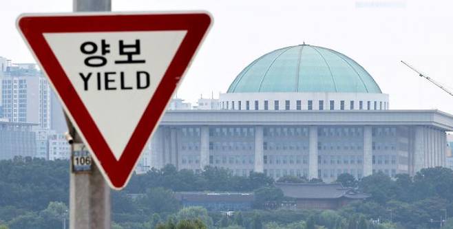 The National Assembly in Yeouido is seen over a traffic sign installed on the Seogang Bridge in Mapo-gu, Seoul on August 4. Yonhap News