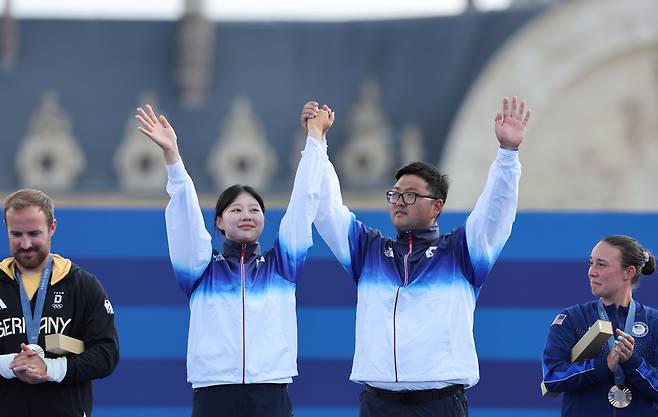 Archers Lim Si-hyeon (second from left) and Kim Woo-jin (second from right) cheer at the medal ceremony for the mixed team event at the Paris Olympics at the Invalides on Saturday. (Yonhap)