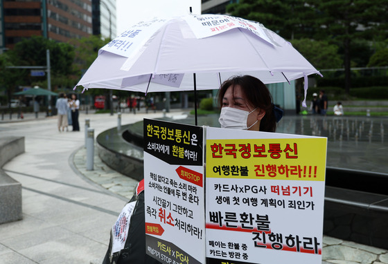 A customer participates in a protest of victims demanding refunds for items bought through credit cards or payment gateways on Qoo10-owned platforms TMON and WeMakePrice. The text reads: "We demand fast refunds. Credit card companies and payment gateways are shifting the blame. Is it our fault for booking our first-ever vacations?" [YONHAP]