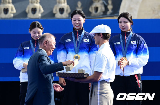 [OSEN=파리(프랑스), 최규한 기자] 한국 여자 양궁이 올림픽 10연패 대기록을 쐈다.임시현(한국체대), 남수현(순천시청), 전훈영(인천시청)으로 구성된 한국 양궁 대표팀은 프랑스 파리 앵발리드에서 열린 ‘2024 파리올림픽’ 양궁 여자 리커브 단체전 결승서 중국(안치쉬안, 리지아만, 양사오레이) 상대로 5-4(56-53, 55-54, 51-54, 53-55, 29-27)로 승리하면서 대회 10연패를 달성했다.시상자로 참석한 정의선 현대차 회장이 양궁 임시현-남수현-전훈영에게 기념품을 전하고 있다. 2024.07.29 / dreamer@osen.co.kr