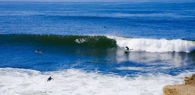 산타크루즈 해변을 가르는 서퍼들