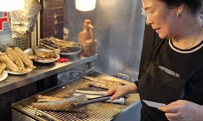 서울의 체감온도가 섭씨 34도까지 치솟던 5일 오후 2시께, 서울 종로구 동대문생선구이골목에서 갈치를 굽고 있는 생선구이집 사장 박재분(69)씨 모습. 김채운 기자