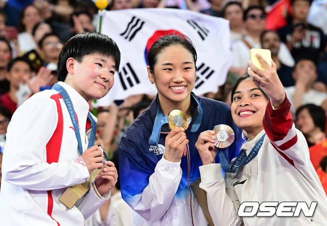 [OSEN=파리(프랑스), 최규한 기자] 5일(한국시간) '셔틀콕 여제' 안세영(22, 삼성생명)이 꿈에 그리던 올림픽 금메달을 목에 걸었다.세계 랭킹 1위 안세영은&nbsp;5일 오후(이하 한국시간) 프랑스 파리 포르트 드 라샤펠 경기장에서 열린 2024 파리올림픽 배드민턴 여자 단식 결승전에서 랭킹 9위 허빙자오(중국)를 2-0으로 꺾고 금메달을 획득 했다. &nbsp;금메달 한국 안세영(가운데)와 은메달 중국 허빙자오(왼쪽), 동메달 인도네시아 툰중과 기념촬영을 하고 있다. 2024.08.05 / dreamer@osen.co.kr