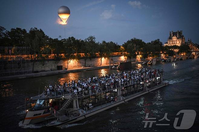 사람들이 2024년 7월30일 파리 센 강에서 보트를 타며 파리 올림픽 성화대를 촬영하고 있다. ⓒ AFP=뉴스1 ⓒ News1 김지현 기자