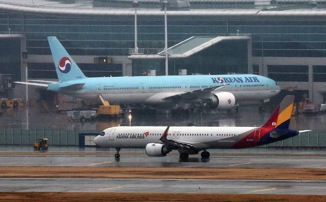 인천국제공항 계류장에 세워진 대한항공 항공기 앞으로 아시아나 항공기가 지나가고 있다. 2024.1.14/뉴스1