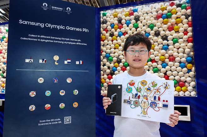 파리 마리니 광장의 '삼성 올림픽 체험관'에서 삼성 올림픽 핀 마스터가 된 벤 최(미국)가 수집한 16개의 삼성 올림픽 핀을 들고 있다. 삼성전자 제공