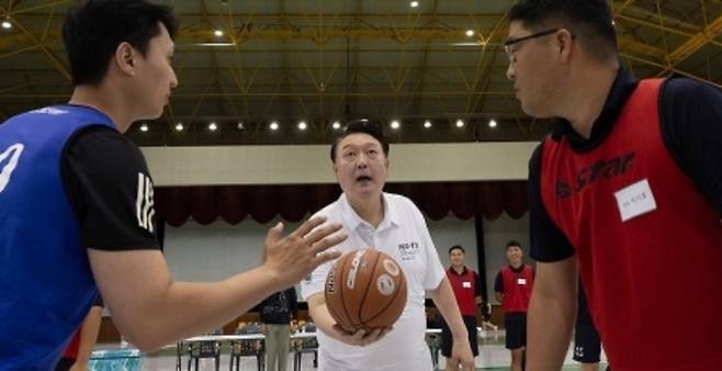 여름휴가를 맞아 경남 진해 해군기지에서 머물고 있는 윤석열 대통령이 7일 오후 진해기지사령부체육관에서 농구 시합 중인 장병들에게 점프볼을 던져주고 있다. 연합뉴스