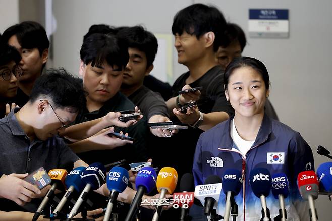 파리 올림픽 배드민턴 여자 단식 금메달리스트 안세영이 7일 인천공항 입국장에서 취재진 질문을 받고 가볍게 웃고있다. 영종도 | 문재원 기자