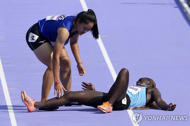 쓰러진 남수단 선수(오른쪽)를 걱정해주는 라오스 육상 선수 [AP=연합뉴스]