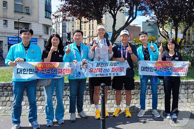 이상일 용인시장(왼쪽 세번째)이 7일 오전(현지시간) 파리에서 올림픽 남자 높이뛰기 경기에 출전한 우상혁 선수(가운데)와 함께 우 선수의 선전을 기원하며 화이팅을 외치고 있다.(용인시 제공