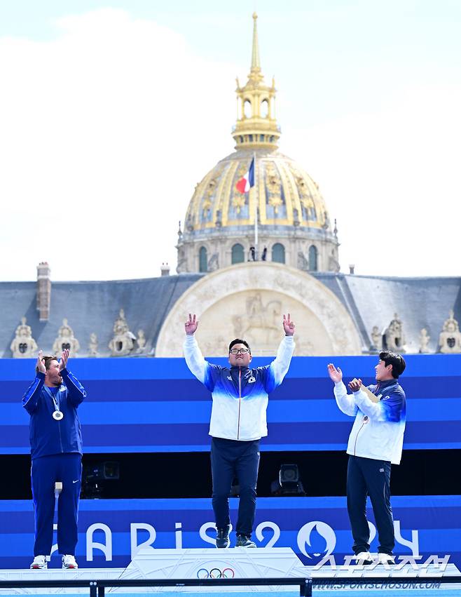 양궁 국가대표 김우진(가운데)이 4일(한국 시간) 프랑스 파리 앵발리드에서 열린 파리올림픽 양궁 남자 개인전 미국의 브래디 엘리슨과의 결승전에서 승리하며 3관왕을 달성한 뒤 시상대에 오르고 있다. 왼쪽부터 은메달 미국의 브래디 엘리슨, 금메달 김우진, 동메달 이우석. 김우진은 한국 선수 올림픽 역다 최다인 5개의 금메달을 획득했다. 파리(프랑스)=정재근 기자 cjg@sportschosun.com/2024.8.4/