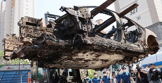 Police officers tow the electric car that caught fire in the underground parking lot of the Cheongna International City apartment complex in Incheon after a forensic examination on Monday. The fire, which started on the morning of Aug. 1, burned over 40 vehicles and damaged more than 100 others. (Yonhap)