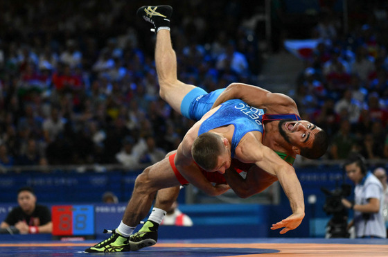 Azerbaijan's Hasrat Jafarov (red) wrestles Moldova's Valentin Petic (blue) in the men's greco-roman 67-kilogram wrestling quarterfinal at the Champ-de-Mars Arena in Paris on Wednesday.  [AFP/YONHAP]