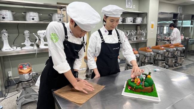 경북 성주군 선남면 명인고로 유학 온 베트남 출신 도 티 티 냐(17·오른쪽) 양과 도 비엣 칸(17) 군이 교내 실습실에서 케이크를 만들고 있다.  명인고 제공
