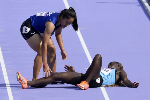 육상 여자 100ｍ 예선에서 남수단의 루시아 모리스가 넘어진 것을 라오스 선수인 실리나 파 아파이가 도와주는 모습 AP 연합뉴스