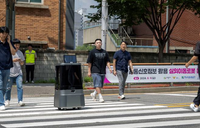 현대차·기아 로보틱스랩 자율주행 배송로봇이 시민과 함께 횡단보도를 횡단하는 모습.(사진=현대차·기아)