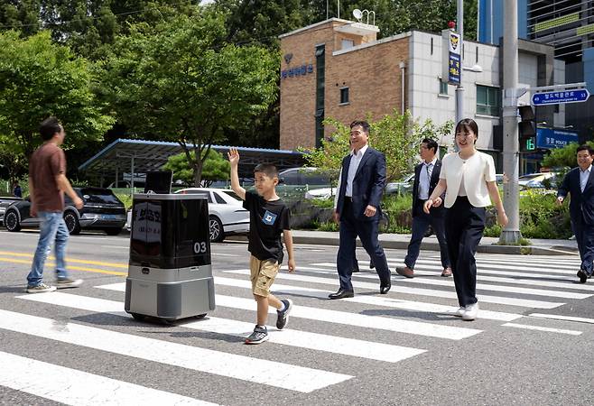 현대차그룹이 자율주행 배송로봇 횡단보도 주행 실증 시연에 성공했다. 9일 경기도 의왕시 부곡파출소 앞 횡단보도에서 열린 '실외 이동로봇 운행 실증 시연회'에서 현대차·기아 로보틱스랩의 자율주행 배송로봇 '달이 딜리버리(DAL-e Delivery)'가 실시간으로 신호 정보를 인지하며 횡단보도를 안전하게 건너고 있다. 달이 딜리버리에는 경찰청의 실시간 교통 신호정보 수집·제공 시스템과 현대차그룹의 실외 이동로봇 관제 시스템을 연동한 기술이 적용됐다.  현대차그룹