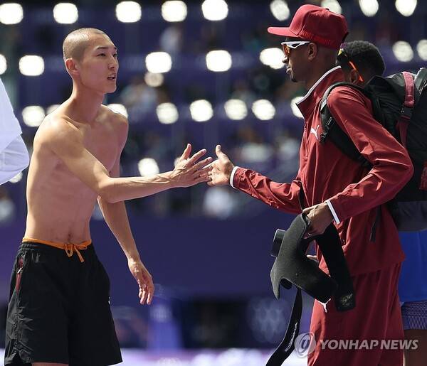 예선에서 인사를 나누는 우상혁(왼쪽)과 무타즈 에사 바르심. ⓒ연합뉴스