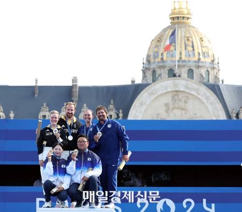 김우진과 임시현이 2일(현지시각) 프랑스 파리 앵발리드에서 열린 2024 파리 올림픽 양궁 혼성 단체 결승 독일과의 경기에서 승리, 금메달을 목에 걸고 기념촬영 하고 있다. 2024.8.2 파리=올림픽사진공동취재단/YSH