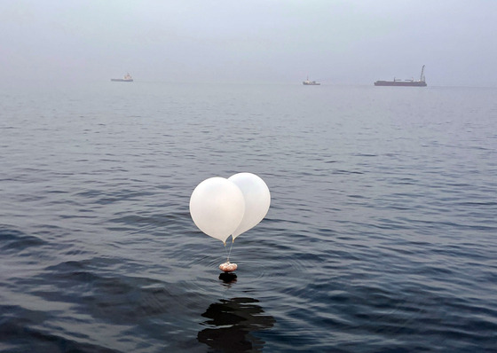 A balloon carrying trash, suspected to have been sent from North Korea, drifts in the sea near Incheon on June 9. [YONHAP]