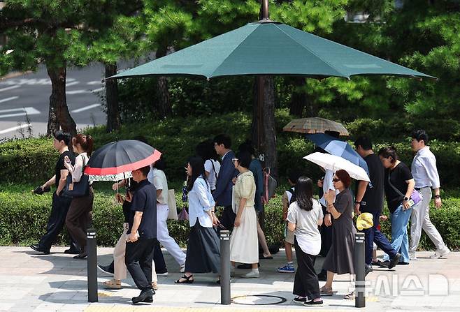 [서울=뉴시스] 김금보 기자 = 서울 중구 세종대로에서 시민들이 폭염을 피해 양산을 쓰고 이동하고 있다. 2024.08.07. kgb@newsis.com