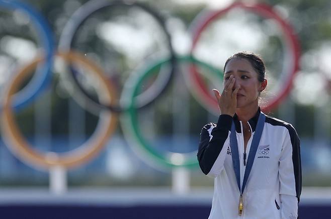 리디아 고가 10일 프랑스 파리 인근 르 골프 나쇼날에서 열린 2024 파리 올림픽 여자골프 최종라운드에서 2타차 우승을 차지한 뒤 시상대에 올라 감격의 눈물을 훔치고 있다.  파리｜로이터 연합뉴스