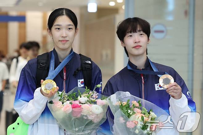 2024 파리 올림픽 일정을 마친 대한민국 태권도 대표팀 김유진(왼쪽), 이다빈이 12일 오후 인천국제공항 제2여객터미널을 통해 귀국, 메달을 들고 포즈를 취하고 있다. 태권도 대표팀은 이번 파리올림픽에서 금메달 2개, 동메달 1개를 수확했다. 2024.8.12/뉴스1 ⓒ News1 신웅수 기자