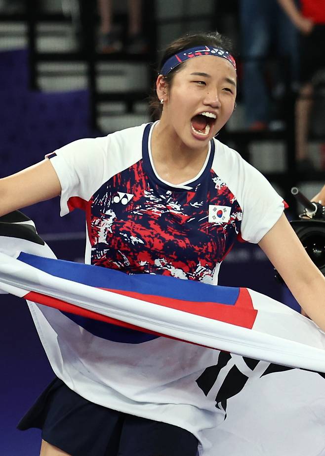 An Se-young cheers while holding the national flag of South Korea after winning gold at the Paris Olympics on Aug. 5. (Yonhap)