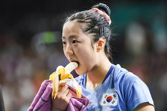 신유빈이 2일(현지시간) 프랑스 파리 사우스 파리 아레나에서 열린 2024 파리올림픽 탁구 여자 단식 4강 중국 천멍과의 경기에 앞서 바나나를 먹고 있다. 연합뉴스