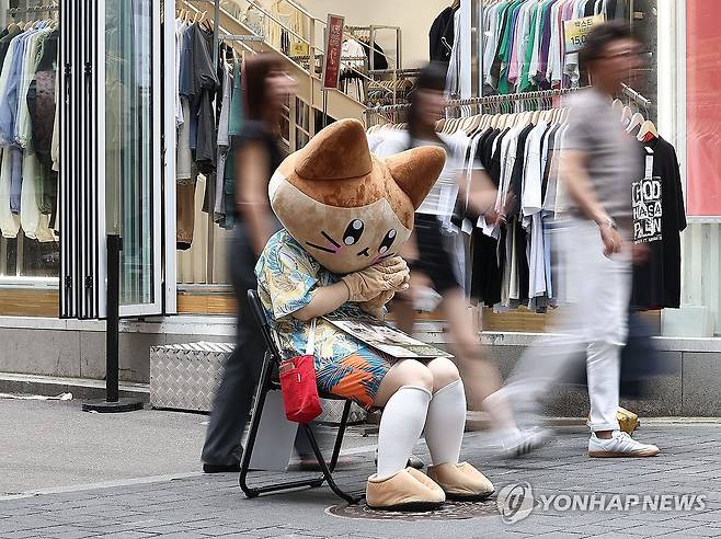 (서울=연합뉴스) 류영석 기자 = 12일 오후 서울 명동거리에서 한 카페 직원이 호객을 하고 있다. 2024.7.12 ondol@yna.co.kr