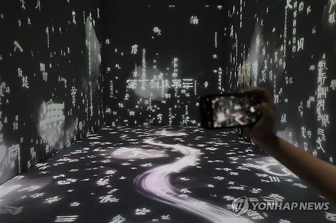 먹향 느껴지는 '추사 김정희의 방' (서울=연합뉴스) 강민지 기자 = 13일 오후 서울 중구 DDP에서 간송미술관 미디어 전시 '구름이 걷히니 달이 비치고 바람 부니 별이 빛난다' 간담회 참석자가 전시를 둘러보고 있다. 2024.8.13 mjkang@yna.co.kr