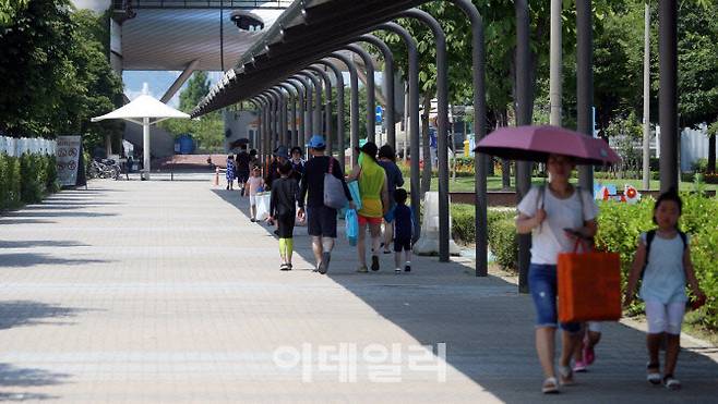 서울 광진구 한강 시민공원을 찾은 시민들이 그늘 아래서 발걸음을 옮기고 있다 (사진=이데일리 신태현 기자)