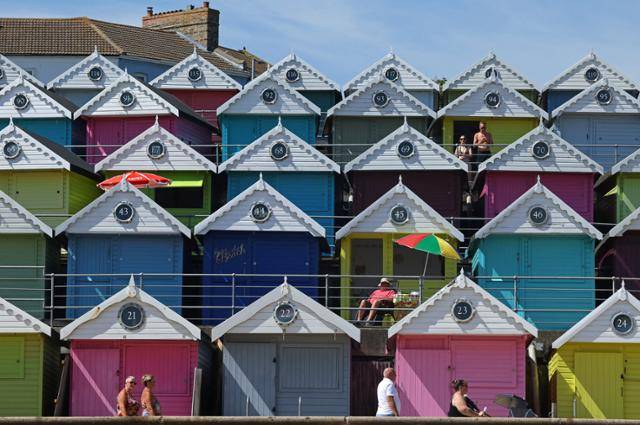 폭염이 계속되고 있는 영국 남부 월턴 온 더 네이즈에서 13일 시민들이 해변에 설치된 오두막에 앉아 휴식을 취하고 있다. 월턴 온 더 네이즈=로이터 연합뉴스