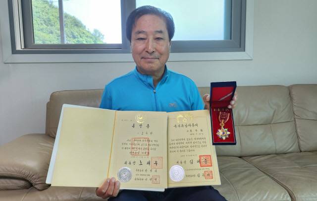 ▲ 독립유공자 후손 조관현씨가 조부의 건국포장과 훈장증, 국가유공자증서를 들고 있다.