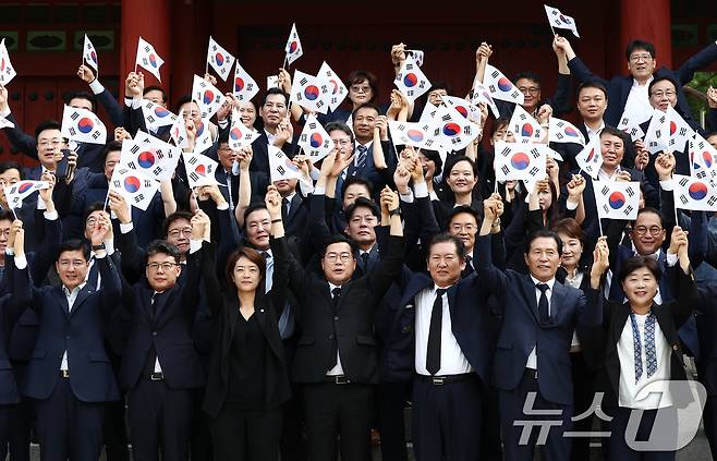 박찬대 더불어민주당 대표 직무대행 겸 원내대표를 비롯한 지도부가 제79주년 광복절인 15일 오전 서울 용산구 효창공원에서 임정요인(이동녕·조성환·차리석) 묘역 참배에 앞서 태극기를 들고 만세삼창을 하고 있다. 이날 민주당 등 야당은 김형석 신임 독립기념관장 임명에 반대해 정부 주최 광복절 경축식에 불참했다. 2024.8.15/뉴스1 ⓒ News1 김민지 기자