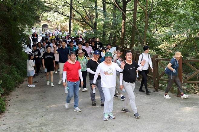 홍태용 경남 김해시장이 김해시 대표 캐릭터 토더기가 그려진 티셔츠를 입고 숲속 둘레길을 걷고 있다. [사진제공=김해시청]