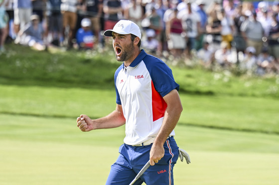 Scottie Scheffler celebrates with a fist pump after making a birdie putt on the 17th hole green during the final round of the Olympic men's golf competition on day nine of the Paris Olympics at Le Golf National on Aug. 4 in Saint-Quentin-en-Yvelines, France. [GETTY IMAGES]