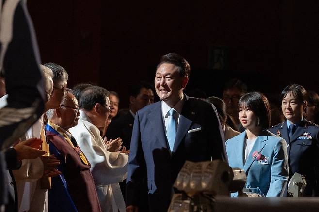 윤석열 대통령이 15일 서울 종로구 세종문화회관에서 열린 제79주년 광복절 경축식에 파리올림픽 유도 은메달리스트 허미미, 한국형 전투기 개발사업 총괄 조은애 중령 등과 함께 입장하고 있다. 연합뉴스