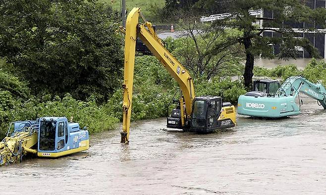 지난 12일 제5호 태풍 마리아가 상륙한 일본 이와테현 이와이즈미에서 불어난 강물에 중장비들이 침수돼 있다. 태풍 마리아는 도호쿠 지방을 관통했다. AP연합뉴스