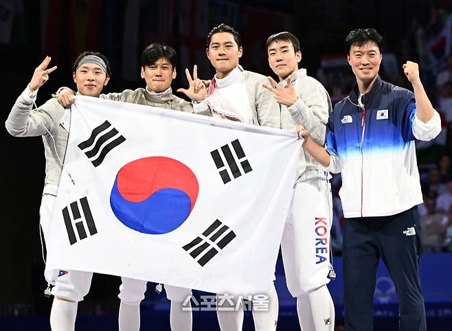 한국 펜싱 남자 대표팀이 1일(한국 시간) 프랑스 파리 그랑팔레에서 열린 2024 파리올림픽 펜싱 남자 사브르 단체전에서 헝가리를 꺾고 금메달을 따내며 올림픽 3연패를 달성한 뒤 태극기를 내보이며 기념촬영을 하고 있다. 2024. 8. 1.  파리 | 박진업 기자 upandup@sportsseoul.com