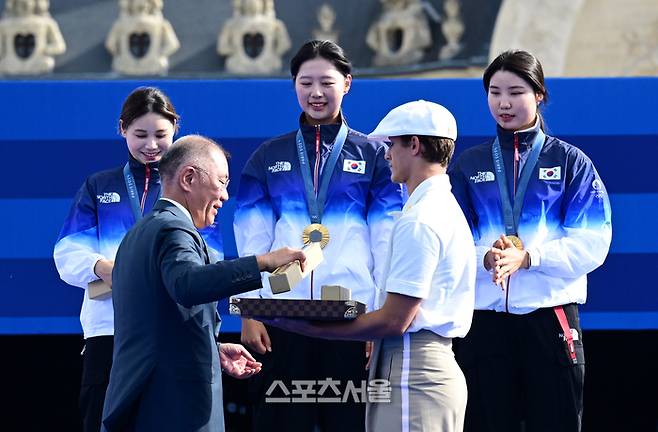 여자 양궁 대표팀의 전훈영(왼쪽부터), 임시현, 남수현이 28일(한국시간) 프랑스 파리 앵발리드에서 열린 2024 파리올림픽 양궁 여자 리커브 단체 결승에서 중국을 꺾고 10회 연속 금메달의 대기록을 달성한 뒤 시상대 위에서 정의선 회장이 건네는 기념품을 받고 있다. 2024. 7. 28.  파리 | 박진업 기자 upandup@sportsseoul.com