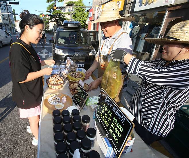 [강릉=뉴시스] 이순철 기자 = 한 시민이 광복절 연휴인 15일 강원 강릉시 강릉문화유산야행 저잣거리 장터에서 (주)대관령송암버섯의 송이향 표고버섯 제품을 구매하고 있다. 제12회 강릉문화유산야행은 15~17일 서부시장, 강릉대도호부관아 일원에서 밤의 문화시장, 밤의 먹거리 등 8가지 테마로 개최된다. 2024.08.15. grsoon815@newsis.com​ *재판매 및 DB 금지